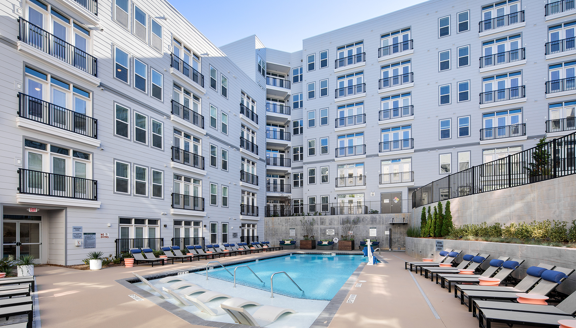 Vine North Hills pool during the day without people, multiple lounge chairs lining the pool