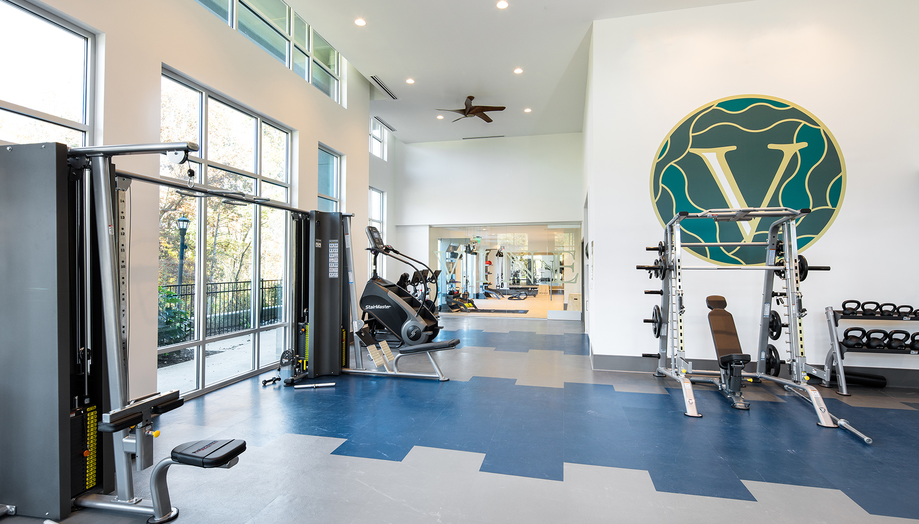 Vine North Hills fitness center with Vine logo on the wall, smith machine, and the stairmaster