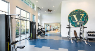 Vine North Hills fitness center with the vine logo on the wall and the stairmaster and smith machine