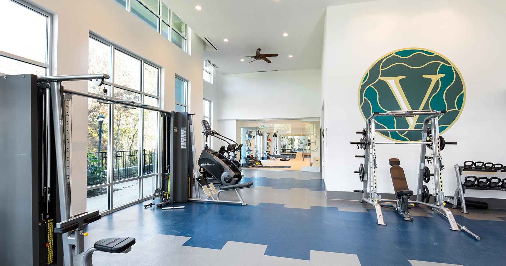 Vine North Hills fitness center with the vine logo on the wall and the stairmaster and smith machine