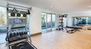 Vine North Hills fitness center with mirrors, equipment, and wooden flooring